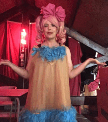 a woman in a pink wig and blue dress