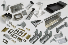 a variety of metal parts are sitting on top of each other on a white surface .