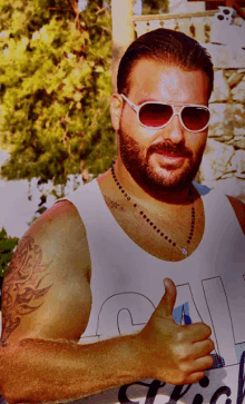 a man with a beard wearing sunglasses and a tank top that says ' a ' on it