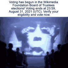 a group of people standing in front of a screen that says voting has begun in the wikipedia foundation board of trustees