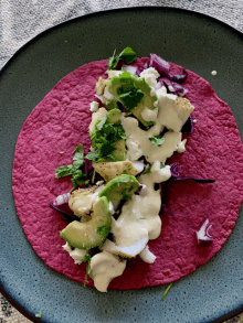 a tortilla with avocado and onions on it