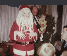 a man dressed as santa claus is holding a child