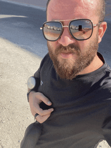 a man with a beard wearing sunglasses and a watch