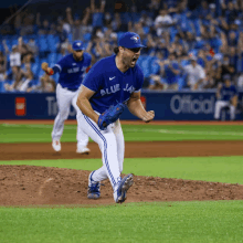 a pitcher for the blue jays celebrates a win on the mound