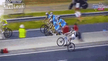 a group of cyclists are racing down a road and one of them is riding a bike on the side of the road .