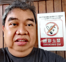 a man in front of a no smoking sign