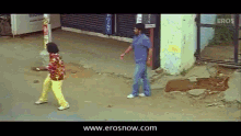 a man in a blue shirt stands next to a woman in yellow pants in front of a building that says police