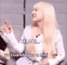 a woman with blonde hair is making a funny face and saying yo cuando veo a nini in spanish .