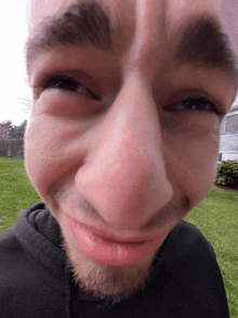 a close up of a man 's face with a black hoodie on