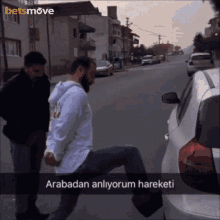 a man in handcuffs is standing next to a white car with the words arabadan anliyorum hareketi written on the bottom