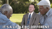 a man in a suit and tie is playing chess with two older men and the caption says it 's a little bit different