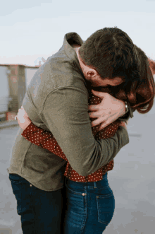 a man in a green shirt holds a woman in his arms