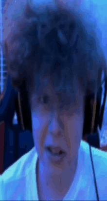 a close up of a person wearing headphones and making a face .