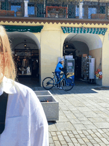 a person riding a bike in front of an atm