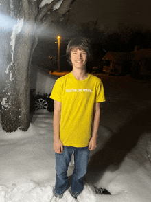 a young man wearing a yellow t-shirt that says you 're on mute