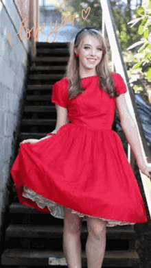 a woman in a red dress stands on a set of stairs with the words " i love you " written on the bottom