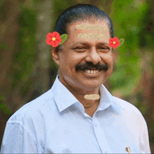 a man with flowers on his forehead is smiling for the camera