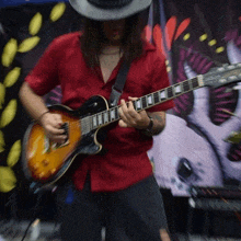 a man with long hair is playing a guitar