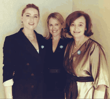 three women are posing for a picture and one of them has a button on her jacket that says ' i am a voter '