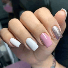 a close up of a woman 's nails with white , pink , and silver polish .