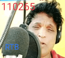 a man wearing headphones is singing into a microphone with 110265 rtb written on the bottom