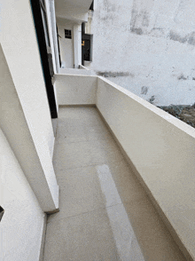 a white balcony with a tiled floor and a white wall