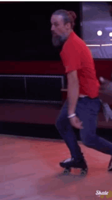 a man wearing a red shirt is rollerblading on a roller rink