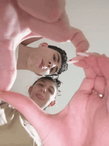 a couple making a heart shape with their hands