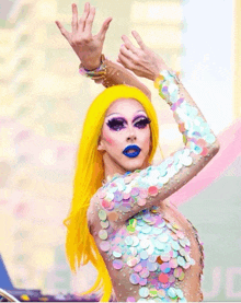 a drag queen with a yellow wig and sequined top