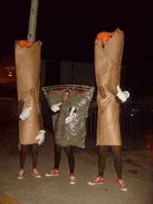 three people dressed up as cigarettes and a bag of marijuana .