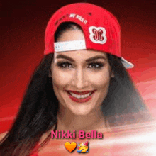 a woman wearing a red hat and smiling with the name nikki bella .