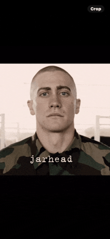 a man with a shaved head is wearing a camouflage shirt and has the word jarhead written on his face