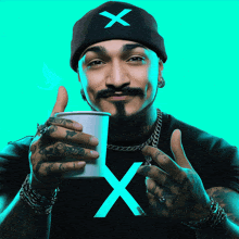 a man wearing a beanie with an x on it is holding a cup