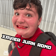 a young man with a backpack and a red shirt with the name xavier juan romo on the bottom