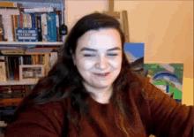 a woman is smiling in front of a bookshelf that has a sign that says ' a few lines ' on it