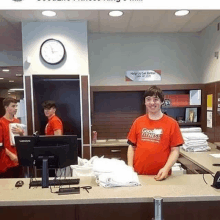 a man wearing a red shirt that says good fitness is standing in front of a counter .