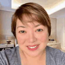 a woman with short hair is smiling for the camera in a living room