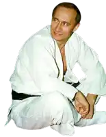 a man in a white karate uniform is sitting on the ground