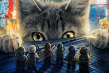 a group of lego figures are standing in front of a cat