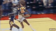 a monkey wearing a party hat is playing basketball on a court with two other players .