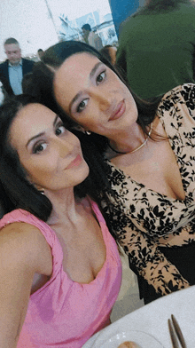 two women posing for a selfie with one wearing a pink top