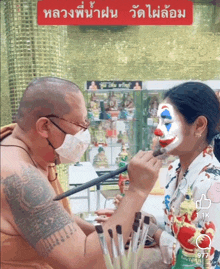 a man is painting a woman 's face with a clown face paint