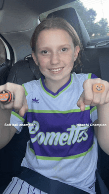 a girl wearing a purple and white jersey with the word comet on it