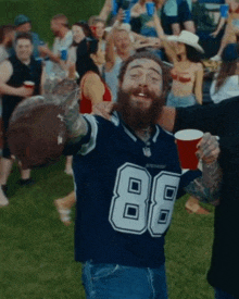 a man with a beard wearing a cowboys jersey with the number 88 on it