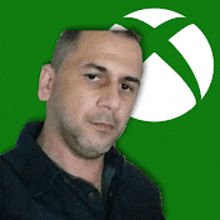 a man in a black shirt is standing in front of a green xbox logo