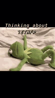 a kermit the frog is laying on a bed with the caption thinking about 1ethfp