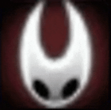 a blurred image of a white object with black eyes on a red background