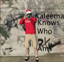 a man wearing a santa hat takes a picture with the words kaleema knows who i am below him