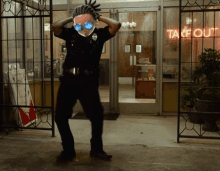 a man in a police uniform is dancing in front of a take out sign