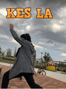 a person standing in front of a sign that says kes la on it